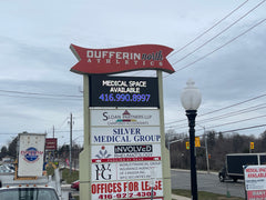 A rectangular outdoor LED sign mounted on a pole, with the text 'Duffrin Athletic Club' and contact information, set against a backdrop of a cloudy sky.